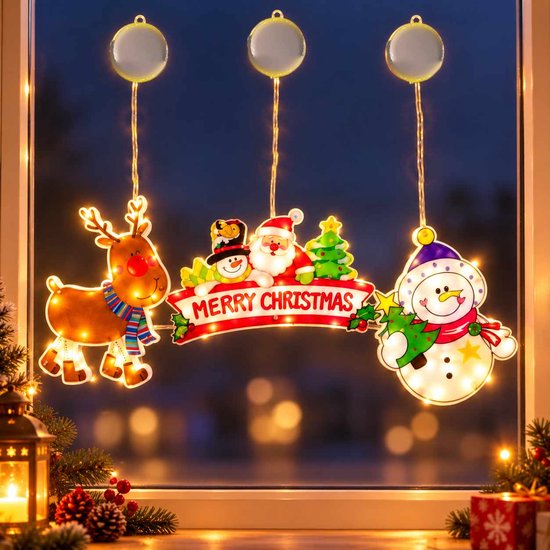 Trois figurines de Noël lumineuses suspendues et fixées à une fenêtre par des ventouses.