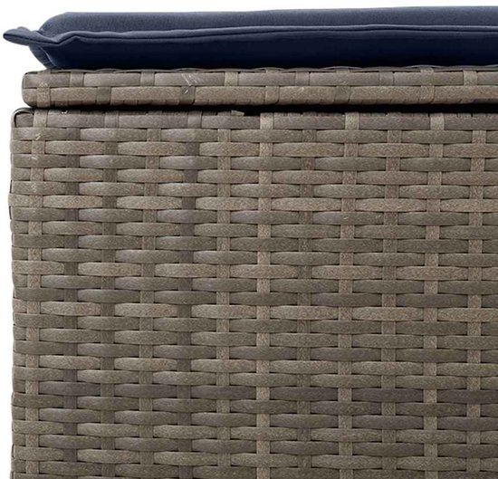 Grijze rotan opbergbox met een blauw kussen.