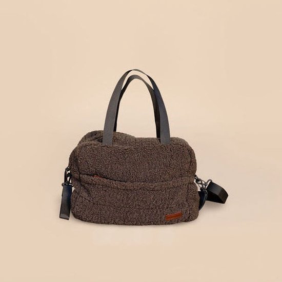 Sac à langer brun en tissu pelucheux avec anses gris foncé et bandoulière amovible.