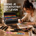 Vrouw tekent aan houten tafel met een set van 168 alcoholmarkers in een zwarte tas. Tekst: Breng je creativiteit tot leven.