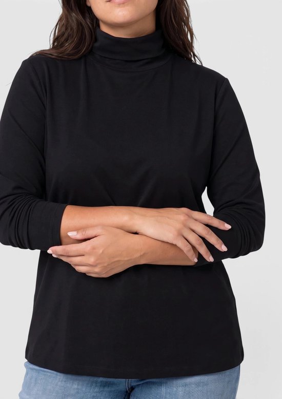 Close-up van de torso van een vrouw in een zwarte coltrui met gekruiste armen.