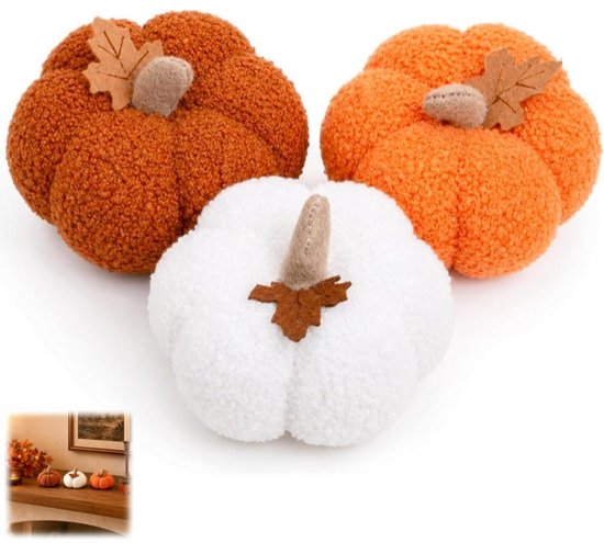 Trois citrouilles en peluche : deux oranges, une blanche. Texture douce avec des feuilles en feutre.