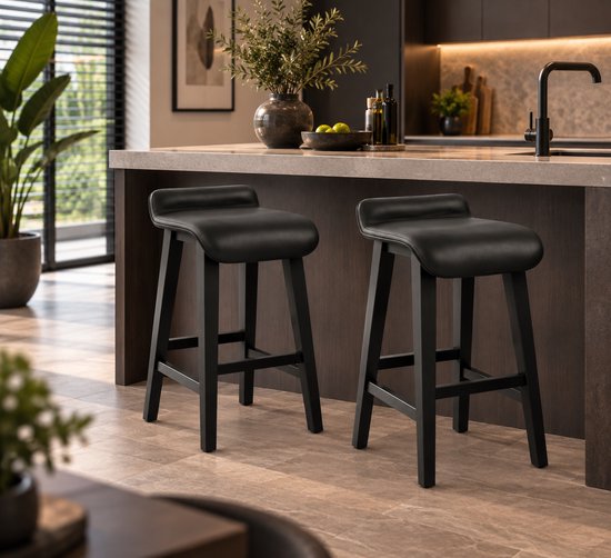 Twee zwarte barkrukken met kunstlederen zittingen en houten poten in een moderne keuken.