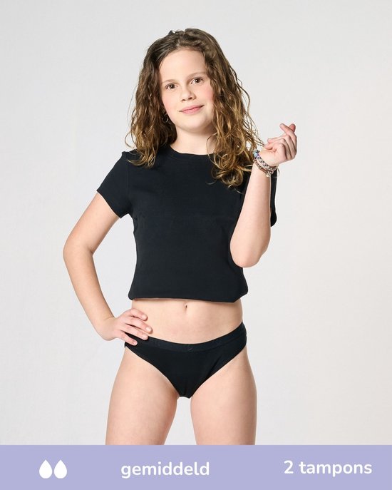 Meisje met lang krullend haar, handen op heupen, draagt zwart crop top en zwart bikinibroekje. Tekst: gemiddeld, 2 tampons.