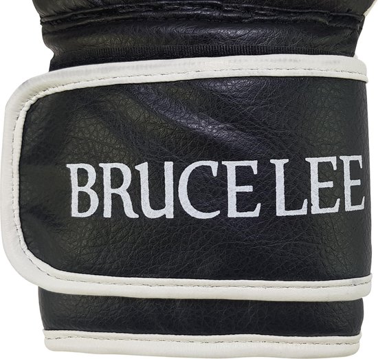 Close-up van een zwarte bokshandschoen met witte polssluiting waarop "BRUCE LEE" staat.