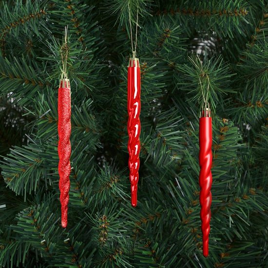 Drie rode, gedraaide kerstboomhangers aan een kerstboom.