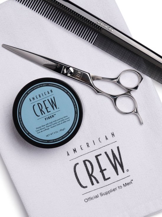 Kam, schaar en American Crew Fiber pot op witte handdoek.