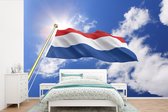Behang - Fotobehang De vlag van Nederland wappert in de lucht - Breedte 525 cm x hoogte 350 cm
