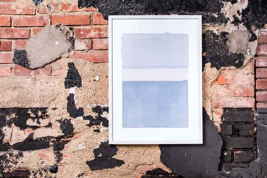 Witte fotolijst met abstracte kunst met blauwe en grijze tinten, hangend aan een verweerde bakstenen muur.