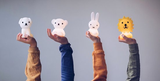 Vier handen houden verlichte dierlampen omhoog: een hond, beer, Miffy en leeuw.