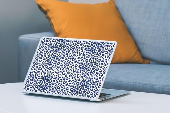 Ordinateur portable avec imprimé léopard bleu sur une table, avec un canapé et un coussin en arrière-plan.