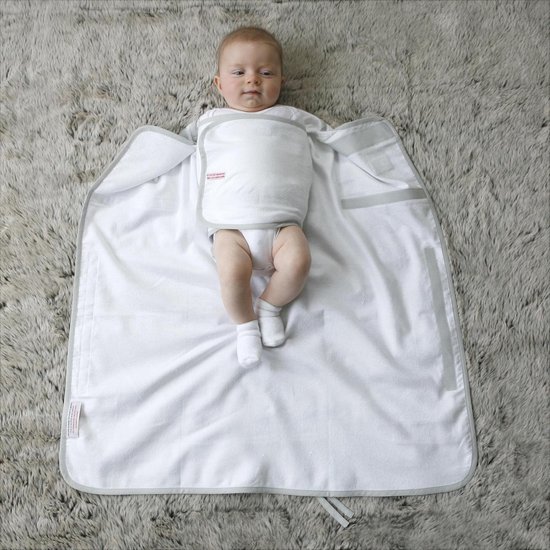 Baby met gestreepte romper en sokjes ligt op een witte, opengevouwen inbakerdoek met grijze rand.