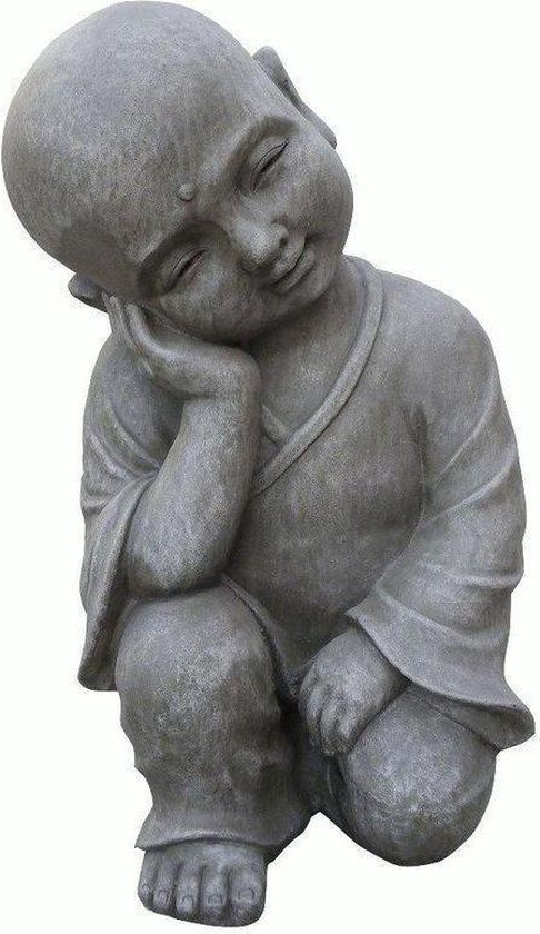 Statue de Bouddha enfant en pierre grise, assis en tailleur, tête sur la main.