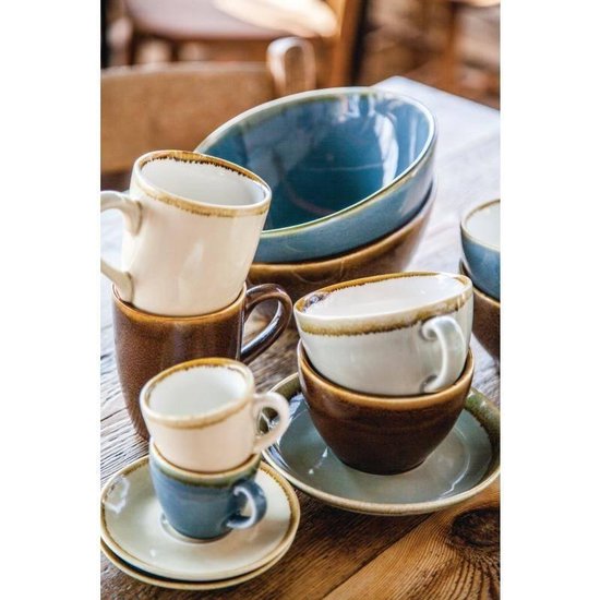 Stapel bruine en witte mokken, blauwe espressokopjes en blauwe schalen.