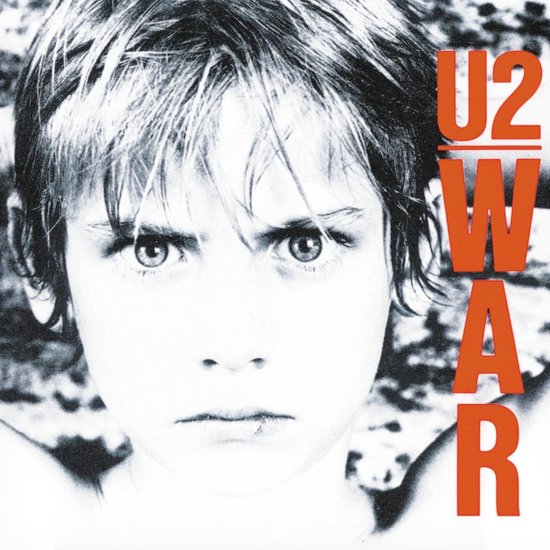 Close-up van een kind met een boze uitdrukking. RODE letters U2 WAR staan aan de rechterkant.