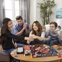 Familie speelt Monopoly Valsspelers Editie, met een handboei aan de pols.