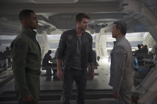 Drie mannen in gevechtspakken in een futuristische ruimte.