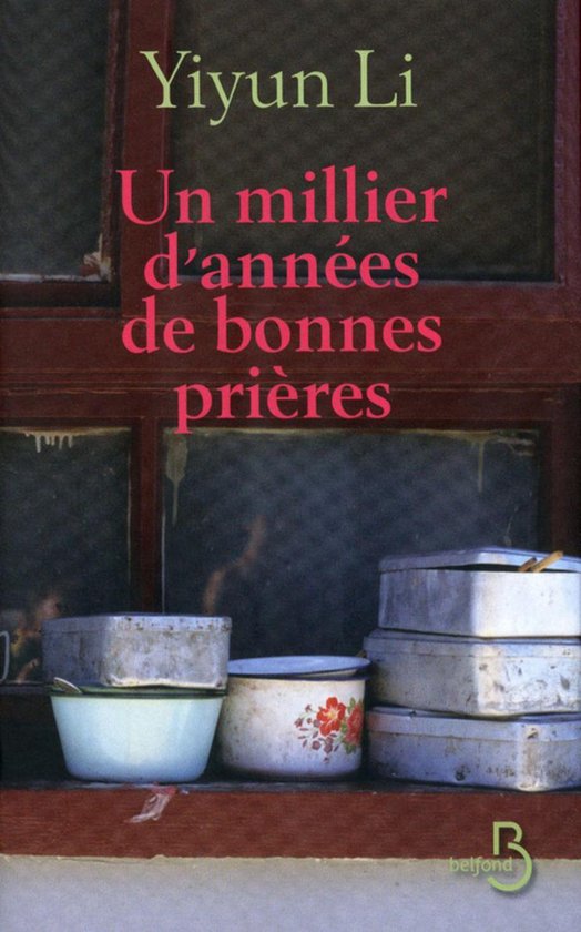 Livre 'Un millier d'années de bonnes prières' de Yiyun Li sur un rebord de fenêtre avec de vieilles casseroles.