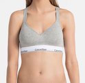 Model in grijze Calvin Klein bralette met V-hals en wit logo-elastiek.