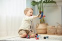 Jongen speelt met een blauw en geel vliegtuigje met rode propeller.