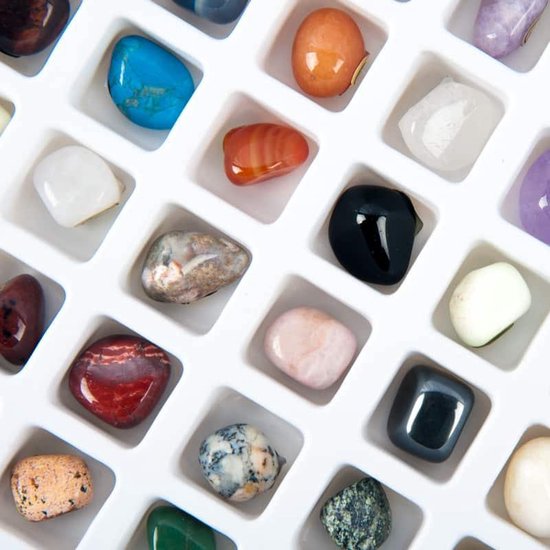 Close-up van diverse edelstenen: blauwe turkoois, oranje agaat, zwarte onyx, roze kwarts, rode jaspis.