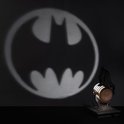 De Batman-lamp projecteert een groot Bat-symbool op een donkere muur.