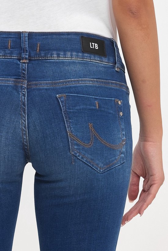Close-up van de achterkant van een donkerblauwe jeans met oranje stiksels en LTB logo.