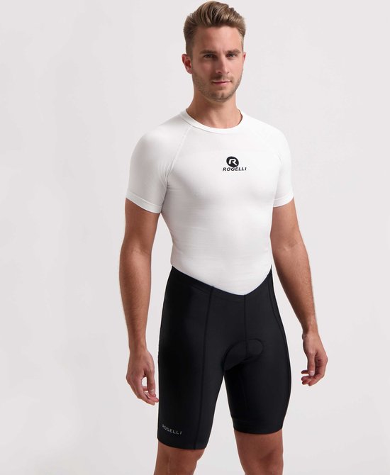 Man van voren gezien, draagt een witte fietsjersey met Rogelli logo en zwarte fietsbroek met Rogelli logo.
