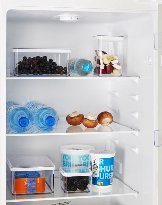 Open Beko koelkast met druiven, fles water, gesneden fruit, bananen, champignons, yoghurtdrank en bramen.