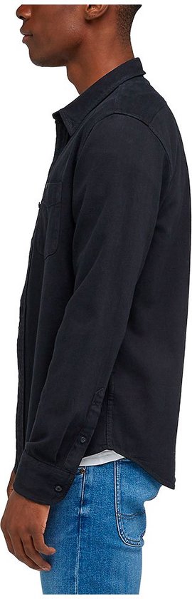 Zijaanzicht van een man in een donkerblauw overhemd met lange mouwen en een spijkerbroek.