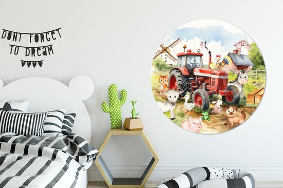 Een ronde muurcirkel met een rode tractor en boerderijdieren, in een kinderslaapkamer met een zwart-wit bed en een cactuslampje.