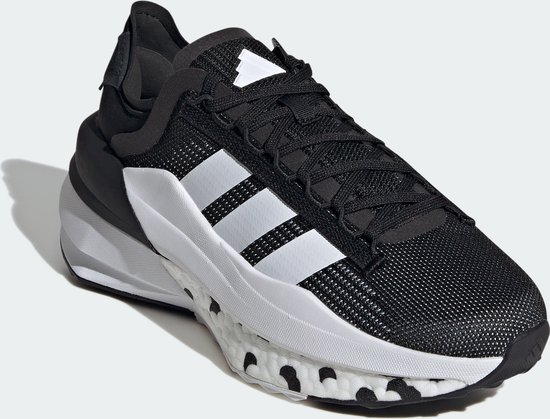 Chaussure de sport noire avec bandes Adidas blanches, semelle blanche à pois noirs, vue de trois quarts.
