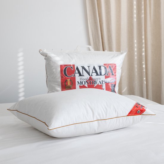 Wit hoofdkussen met gouden bies, label 'CANADA MONTREAL'. Gevuld met 1700 gram veren.