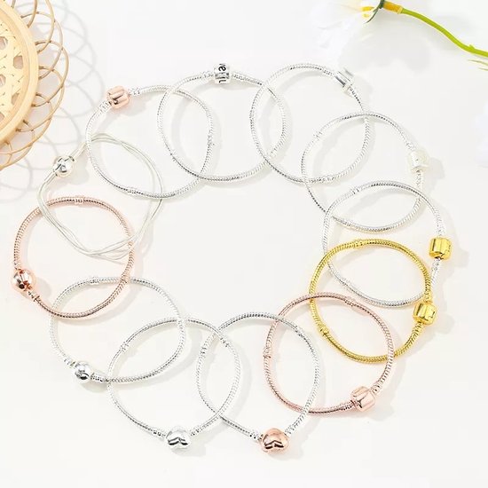 Verschillende bedelarmbanden in zilver-, roségoud- en goudkleur, in een cirkel gelegd.