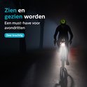 Cycliste de nuit avec un puissant phare avant blanc éclairant la route.