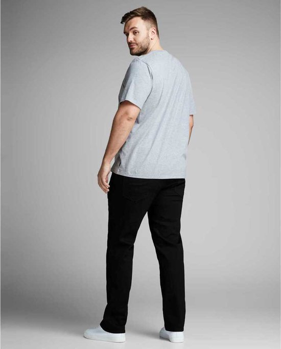 Model draagt een grijs T-shirt en zwarte jeans.