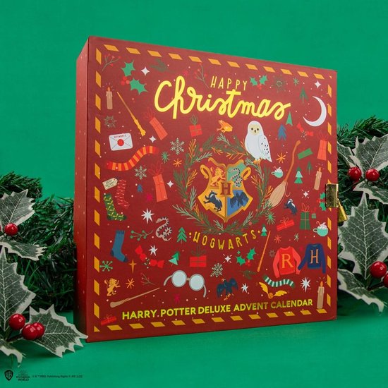 Harry Potter Adventskalender, gesloten, rood met gouden opdruk van kerstmotieven, Hogwarts-wapenschild, en tekst 'Happy Christmas'.
