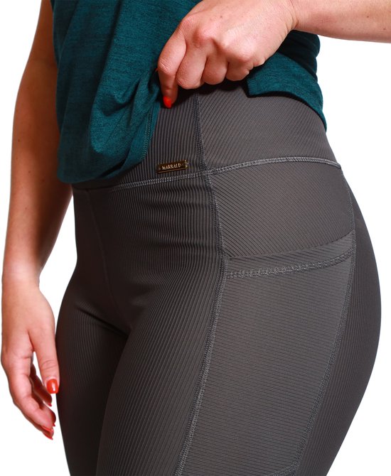 Sluiting van grijze Marrald sportlegging met hoge taille, ribstof en steekzakken. Gouden logo detail op de tailleband.