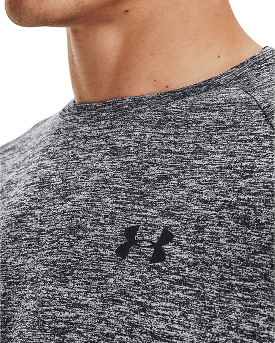 Close-up van een grijs gemêleerd sportshirt met korte mouwen, met het zwarte Under Armour logo op de borst.