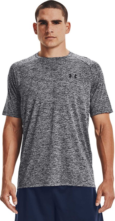 Man met grijs gemêleerd Under Armour sportshirt met korte mouwen en een zwart logo op de borst.