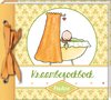 Een kraambezoekboek met een gele kaft met oranje strik, en een ronde afbeelding van een baby in een wiegje met een oranje gordijn, de tekst 'Kraambezoekboek Pauline'.