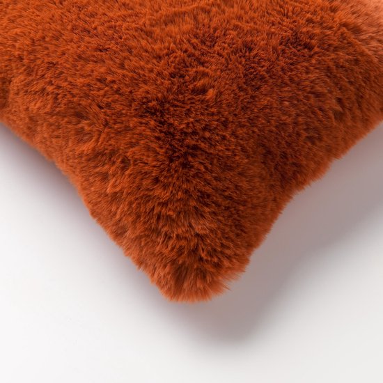 Detail van een oranje bontlook sierkussen.