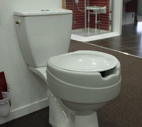 Witte toilet met deksel erop en een witte toiletverhoger met een inkeping.
