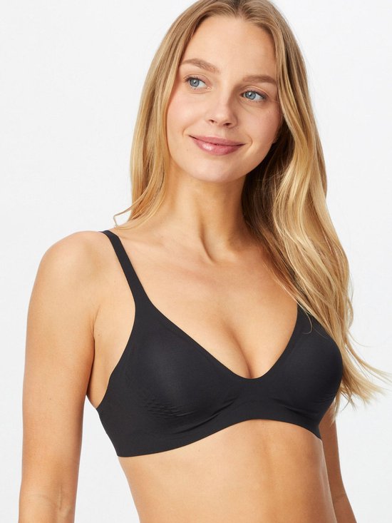 Model met lang blond haar draagt een zwarte T-shirt beha met diepe V-hals.