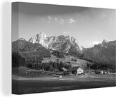 Canvas Schilderij Landschap met een boerderij en bergen in Europa - zwart wit - 120x80 cm - Wanddecoratie
