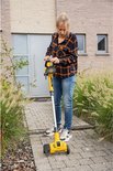 Vrouw met gele onkruidverwijderaar met wielen en steel, in een tuin.