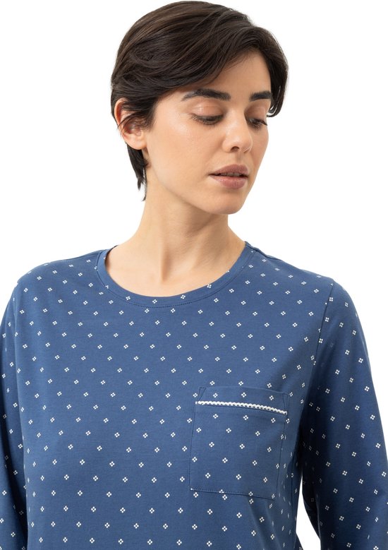 Dichtbij op het blauwe pyjamashirt met all-over witte stippen en een borstzak met witte bies.
