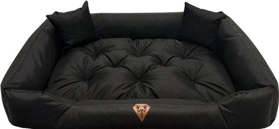 Panier pour chien noir avec matelas capitonné et bords hauts. Deux petits coussins sur le dessus.