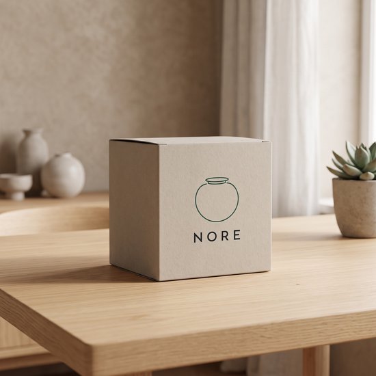 Bruine Nore verpakking met logo van een kom, op een houten tafel.