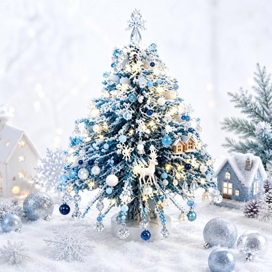 Arbre de Noël bleu et blanc hivernal avec décoration de neige, éclairage et ornements tels que des rennes et des maisons.